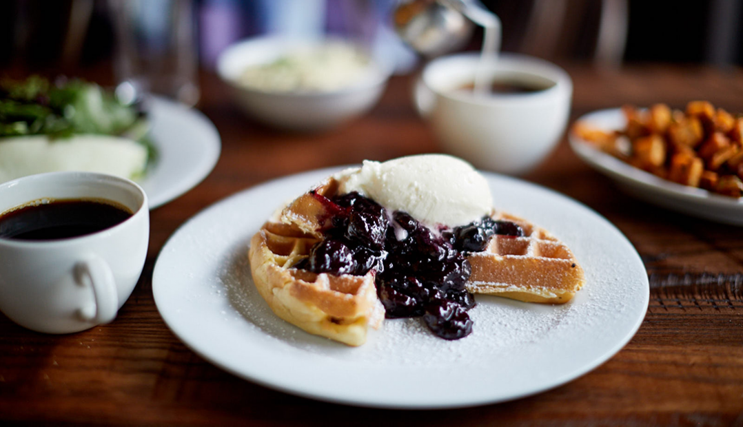 A photo of the buttermilk waffles topped with blueberry compote at The Smith